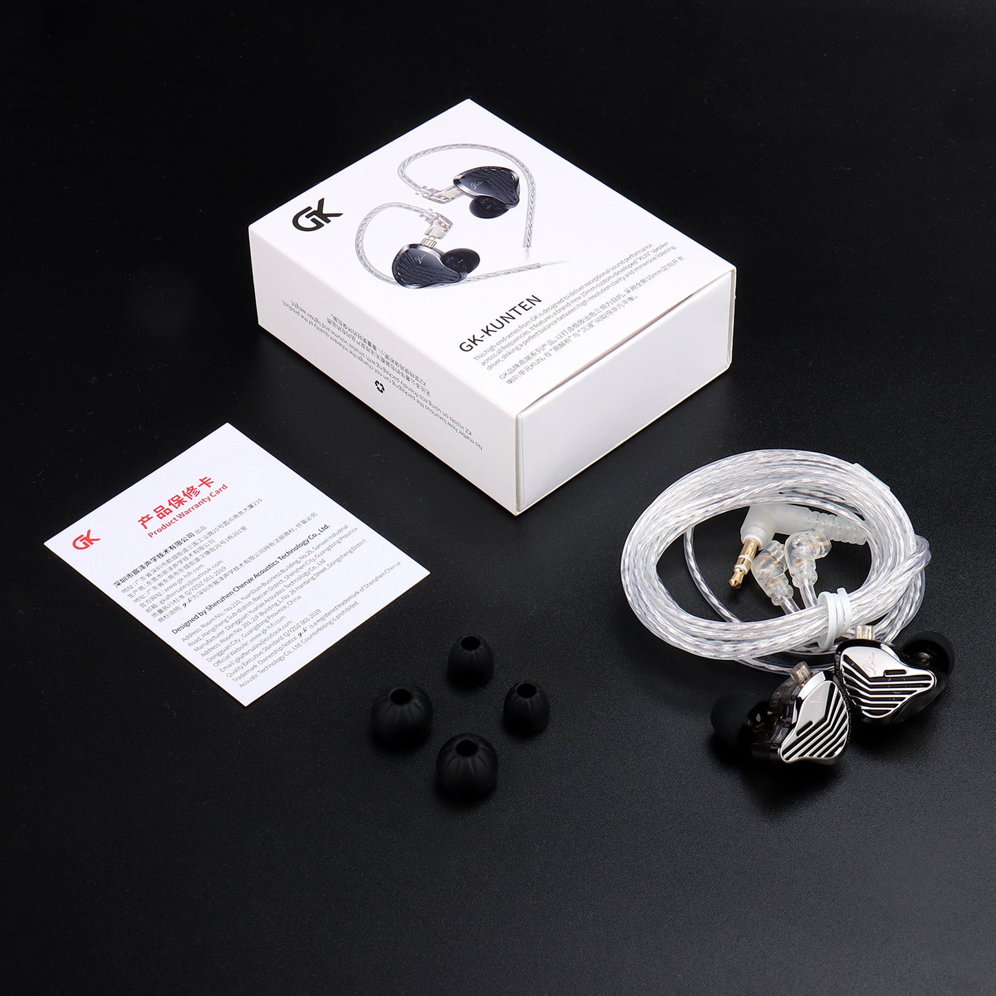 GK Kunten In-ear headphones with packaging, ear tips, and a card on a black background