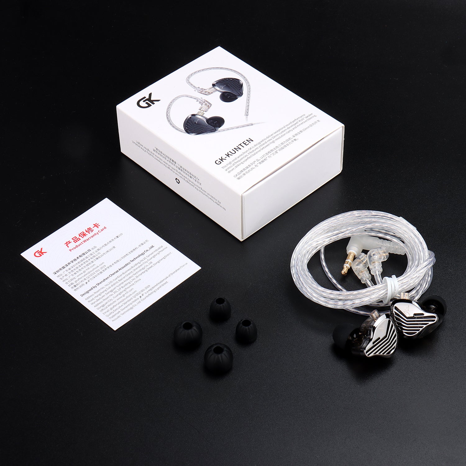 GK Kunten In-ear headphones with packaging, ear tips, and a card on a black background