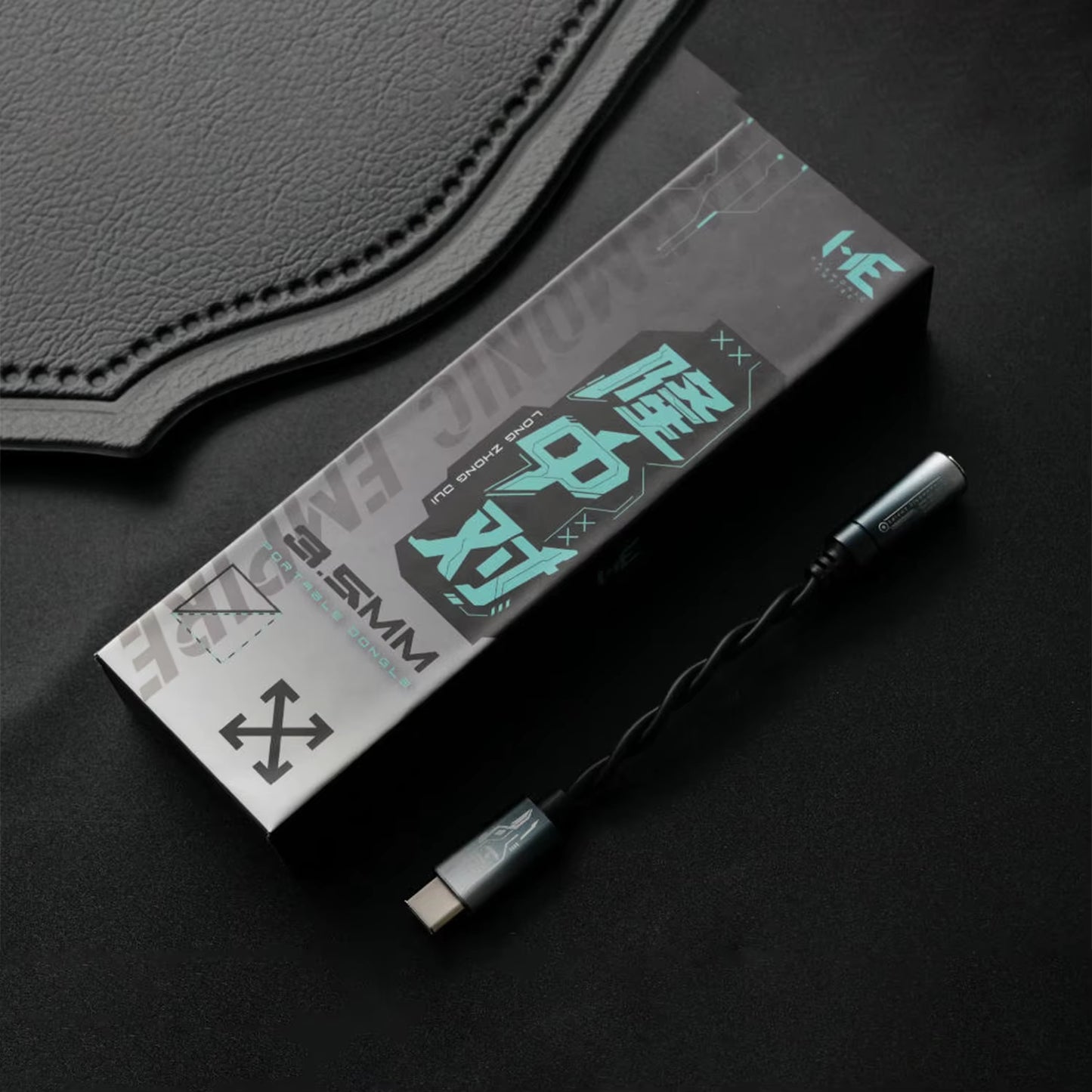 HE Longzhong box and cable on top of a dark fabric surface